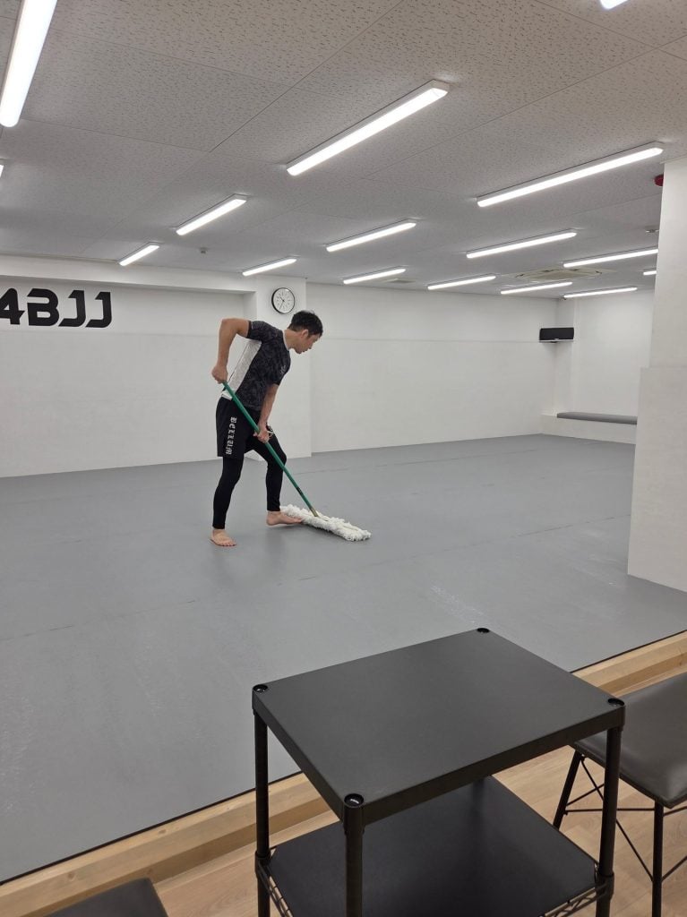 床マットをモップがけする代表の三原