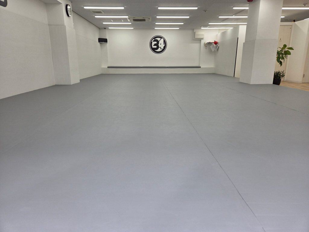 34BJJの広いマットスペース（奥に34ロゴの壁）